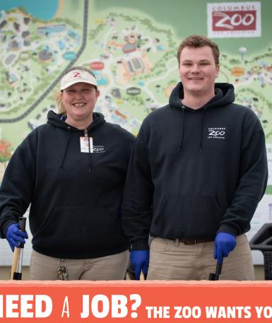 Two team members standing in front of the Columbus Zoo map, smiling