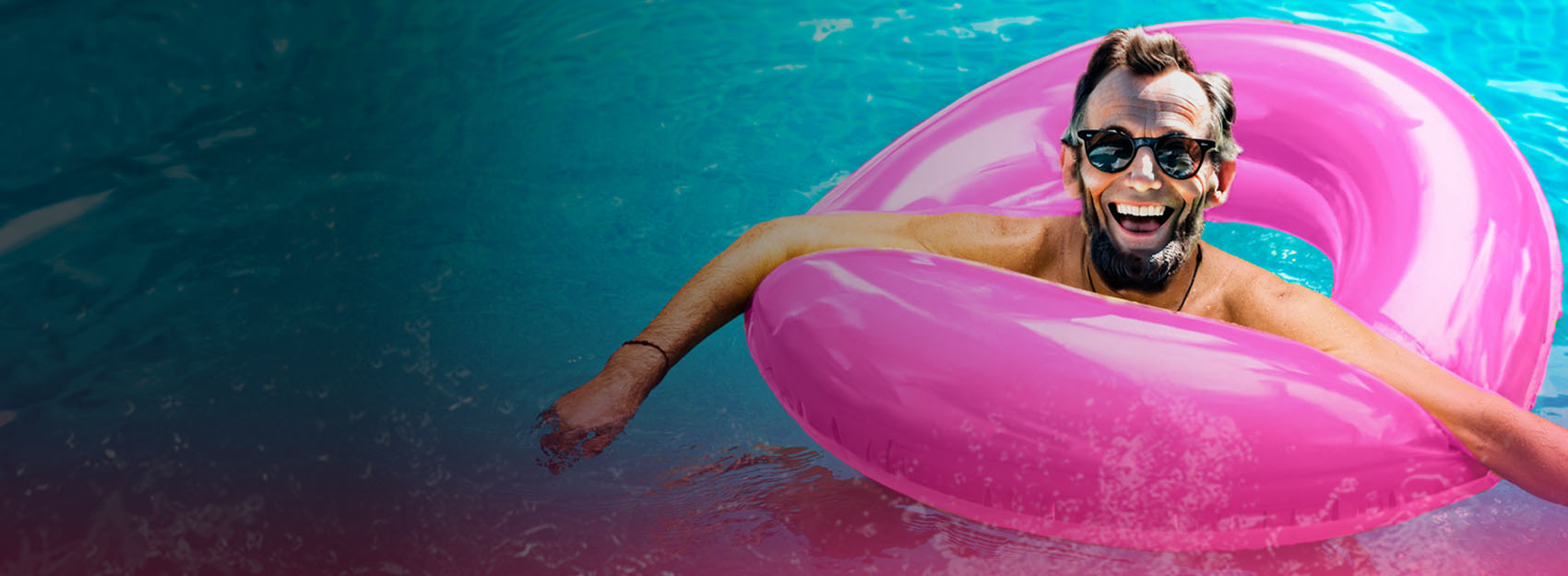 Visitor who resembles President Abe Lincoln with a beard and sunglasses in pink innertube in water