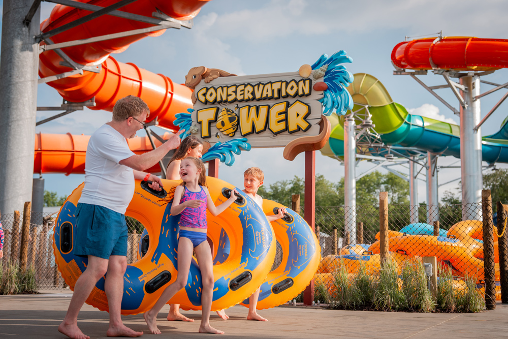 Family with inner tubes outside of Conservation Tower, Zoombezi Bay's award winning slide attraction.