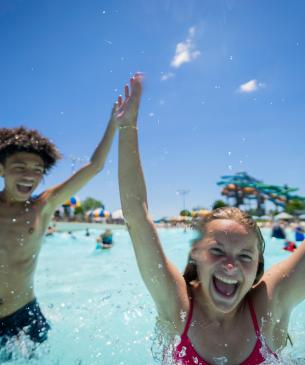 Two kids cheering in the wavepool at Zoombezi Bay waterpark