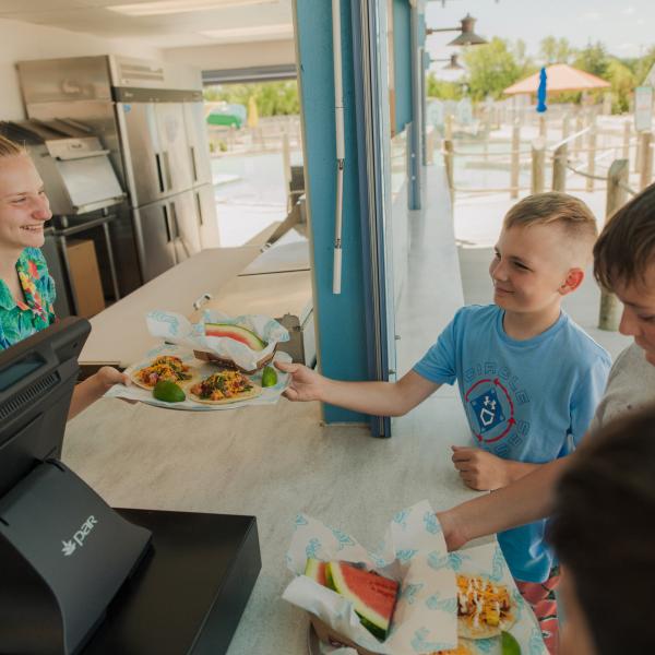 kids taking tacos from employee